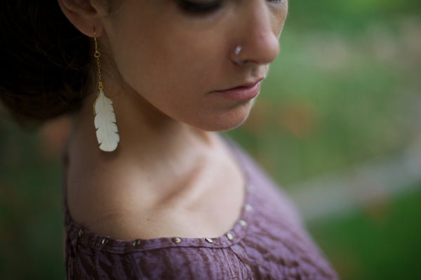 Carved bone earring of a owl feather